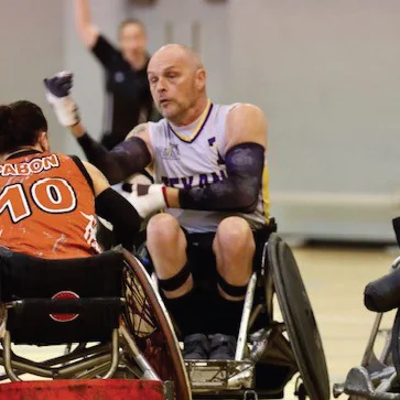 a person in a wheelchair with the arms raised